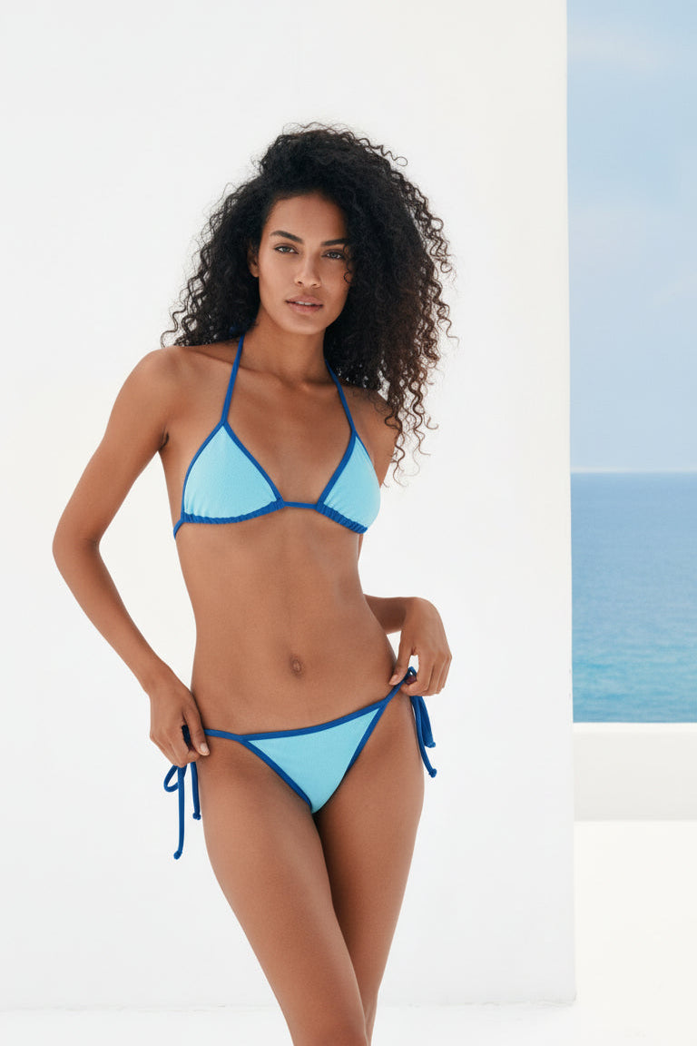 Woman wearing a blue bikini set with a beach background
