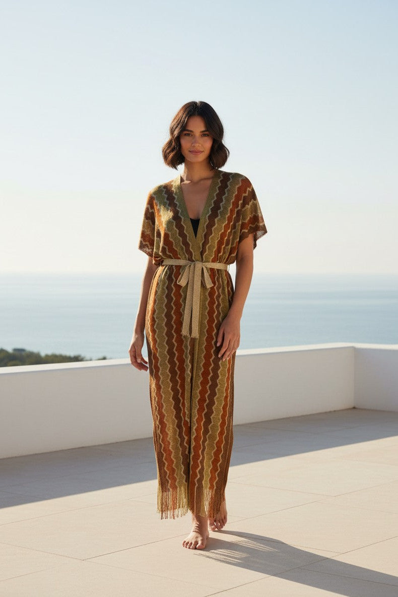 Woman in a patterned dress standing on a rooftop with a clear sky.